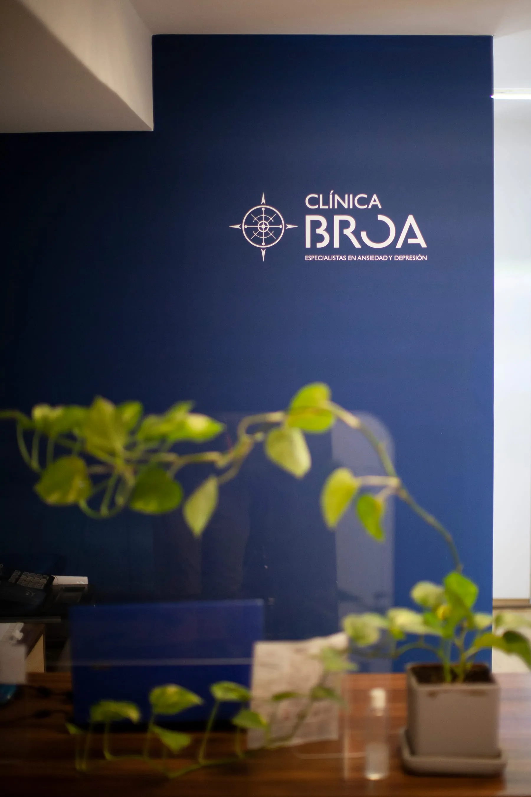Recepción de Clínica Broa con el logotipo en la pared