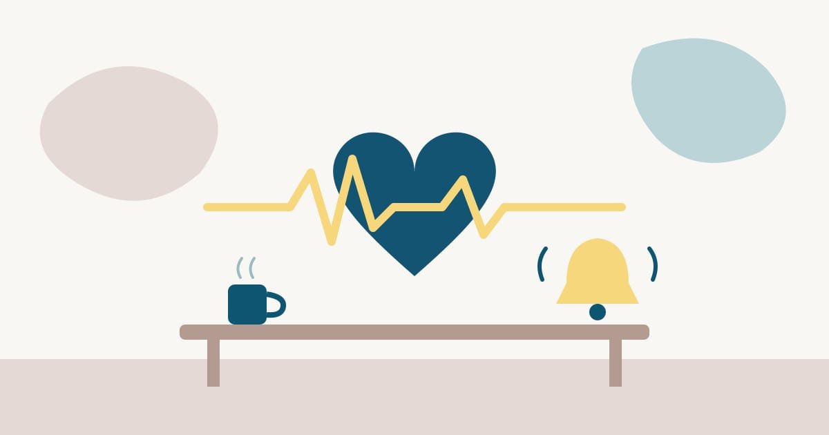 Un corazón azul atravesado por una línea de pulso agitada, junto a una campana de alarma y una taza sobre una mesa