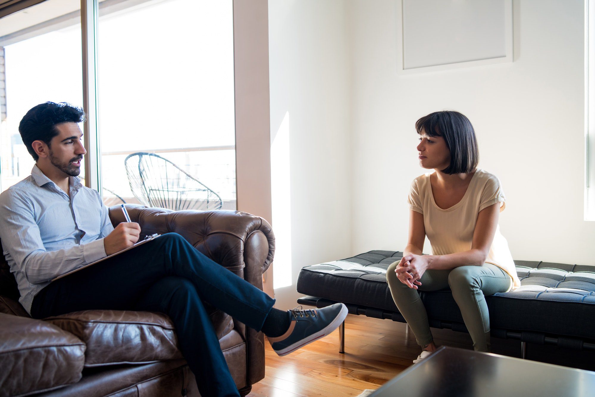 Psychologist talking with patient on therapy session.