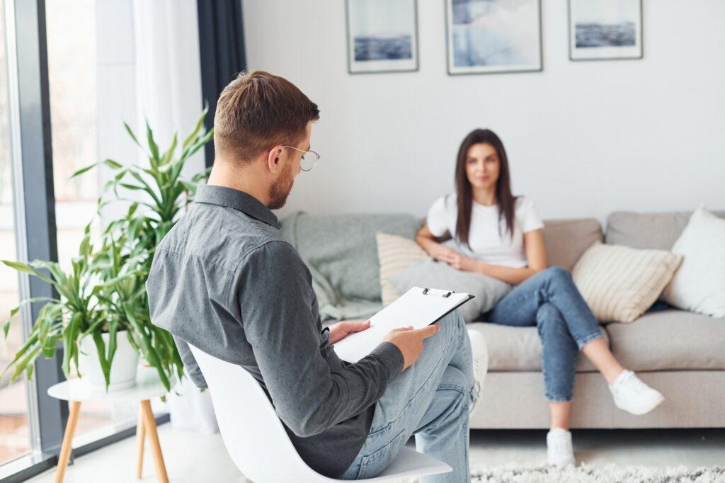 Young woman at a reception at a psychologist. Sits on the sofa